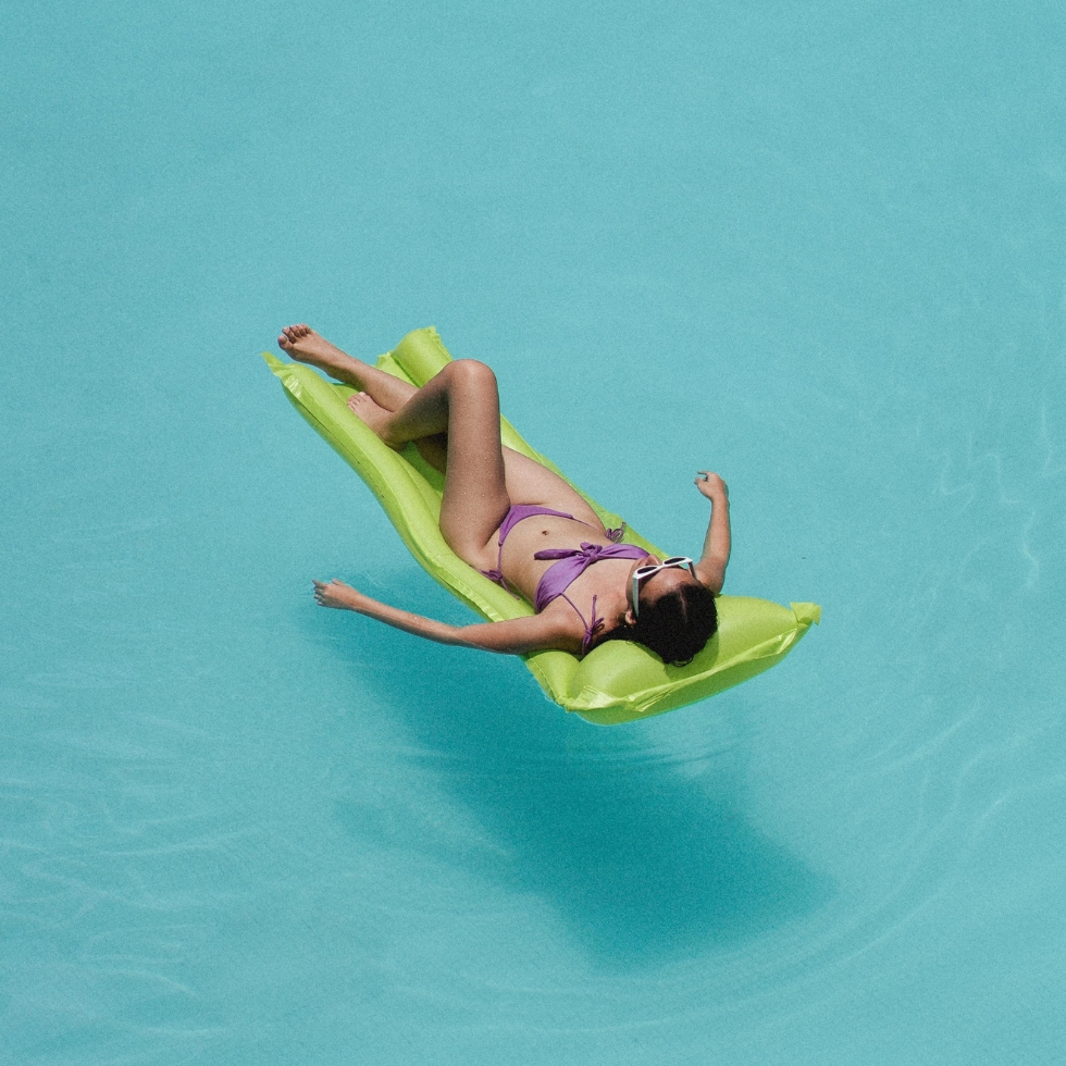 Frau auf Luftmatratze im Pool