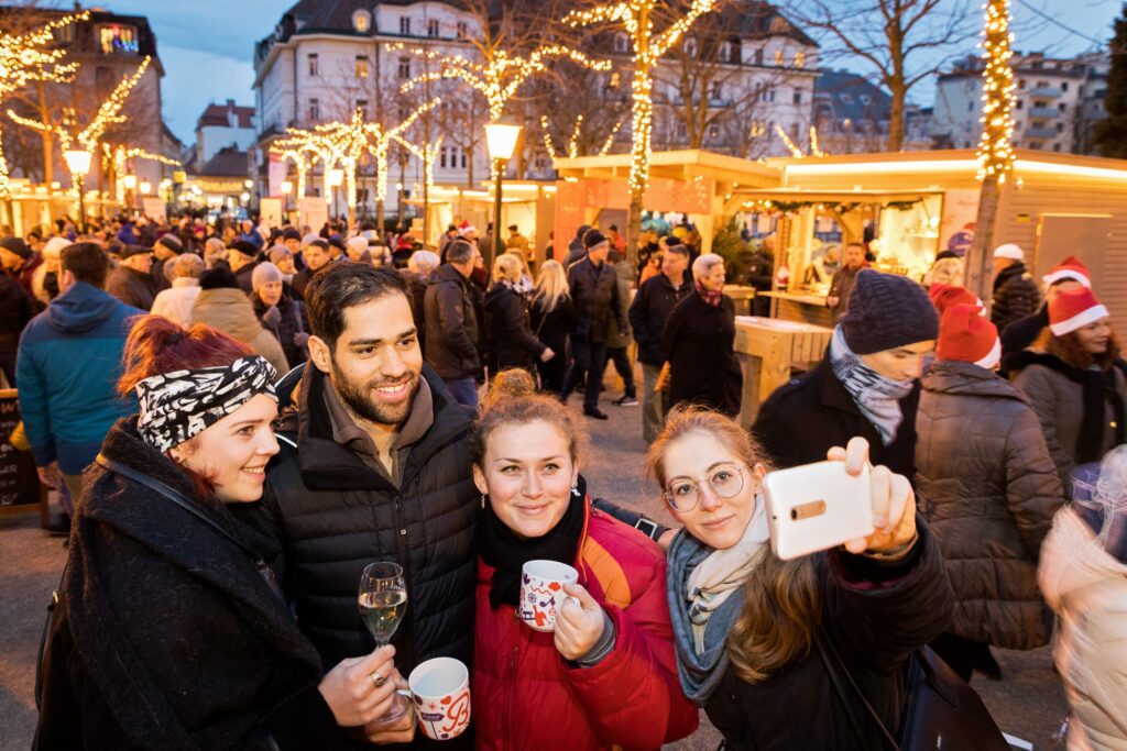 Freunde machen Gruppenselfie am Adventmarkt