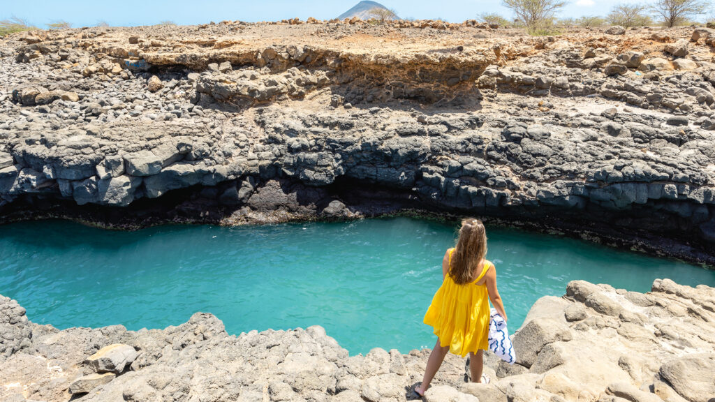 TUI Kapverden: Frau in gelben Kleid steht vor einer Bucht