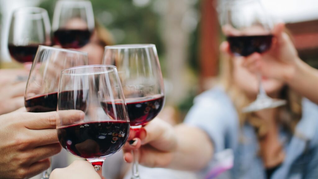 Gläser mit Rotwein werden zusammengestoßen