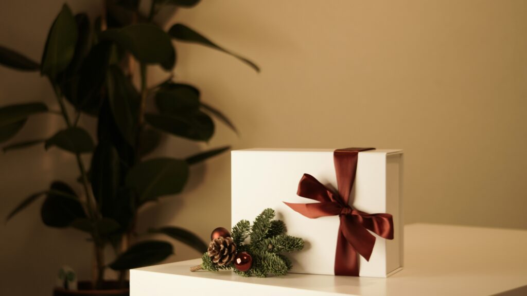 Schön verpacktes Weihnachtsgeschenk mit brauner Schleife und einem Tannenzweig