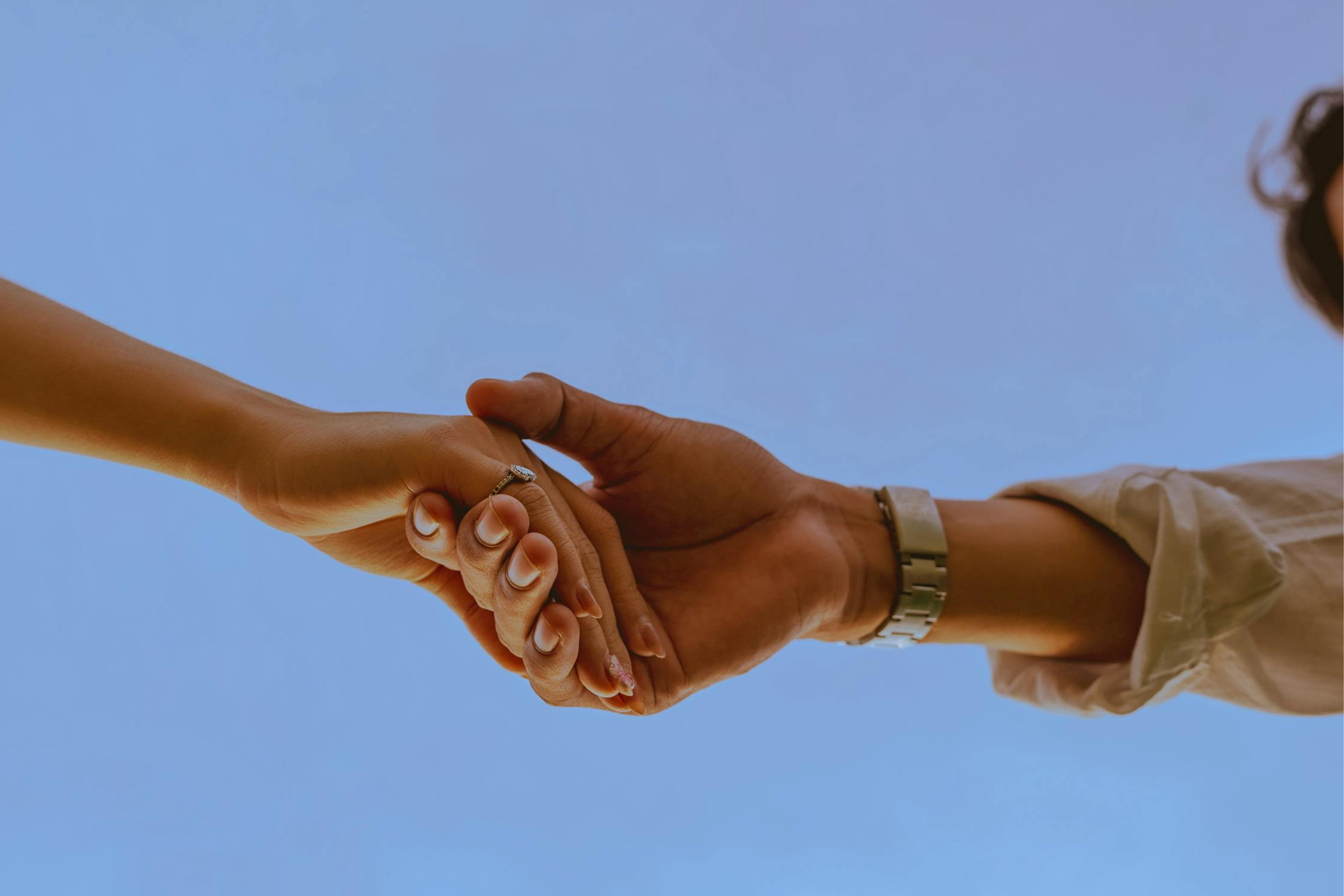 Die Kraft der kleinen Gesten, Symbolbild 2 Hände, ästhetisch, blauer Himmel