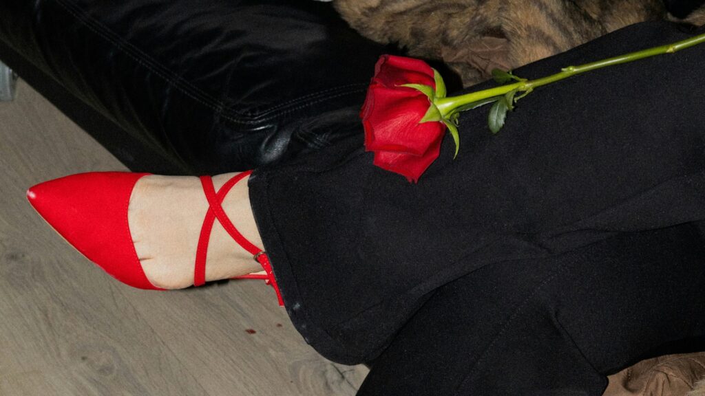 Übereinander geschlagene Beine, rote Schuhe und rote Hose