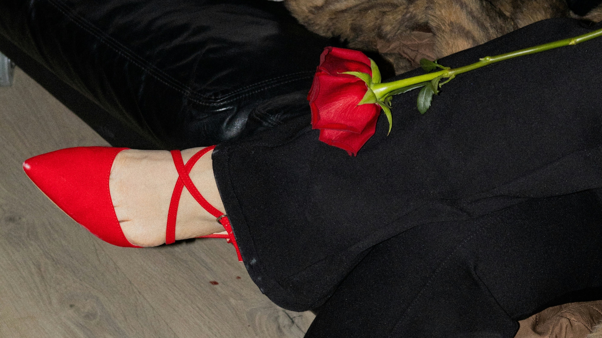 Übereinander geschlagene Beine, rote Schuhe und rote Hose