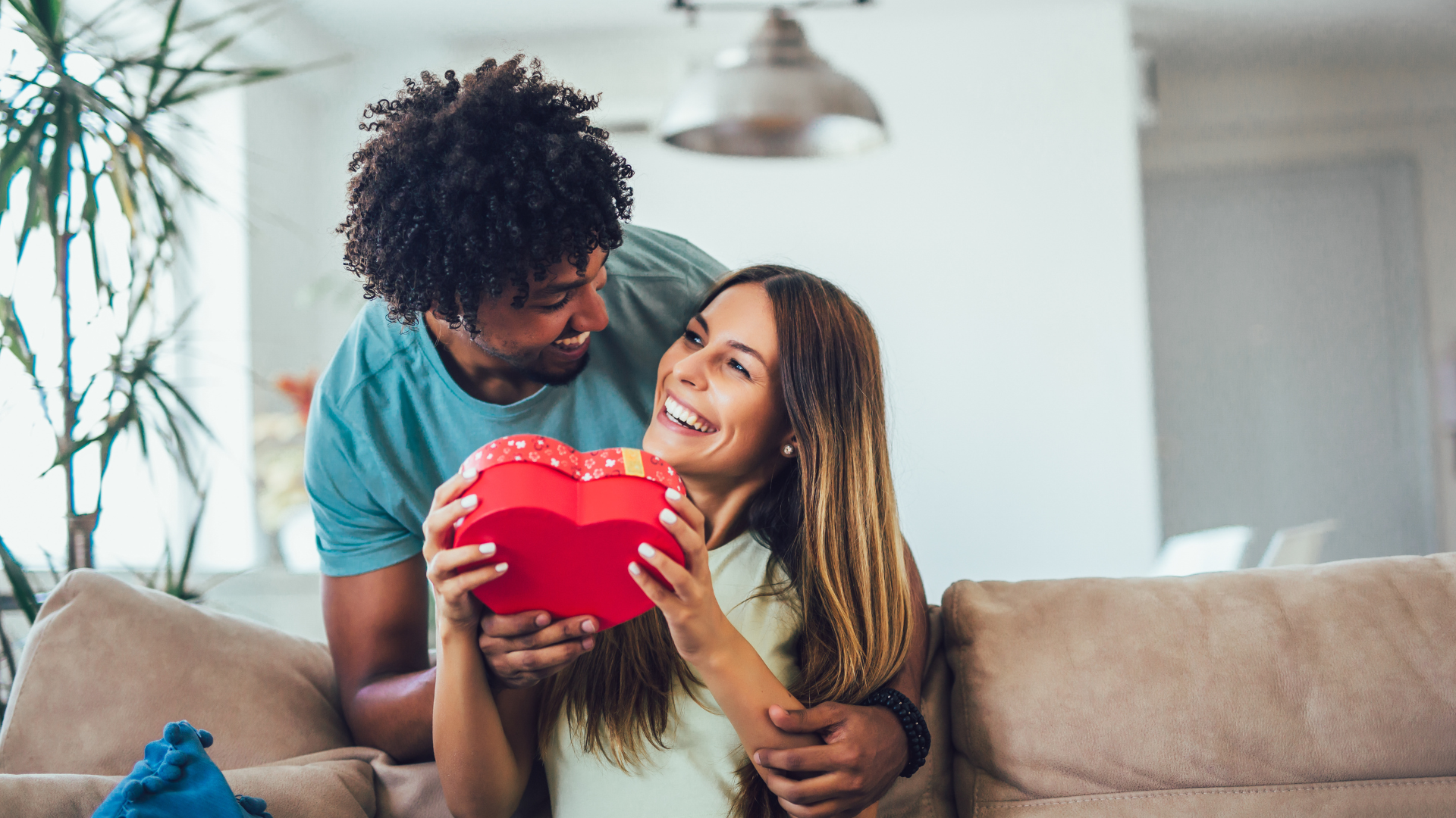 Ein Mann überreicht einer Frau ein Geschenk in Herzform