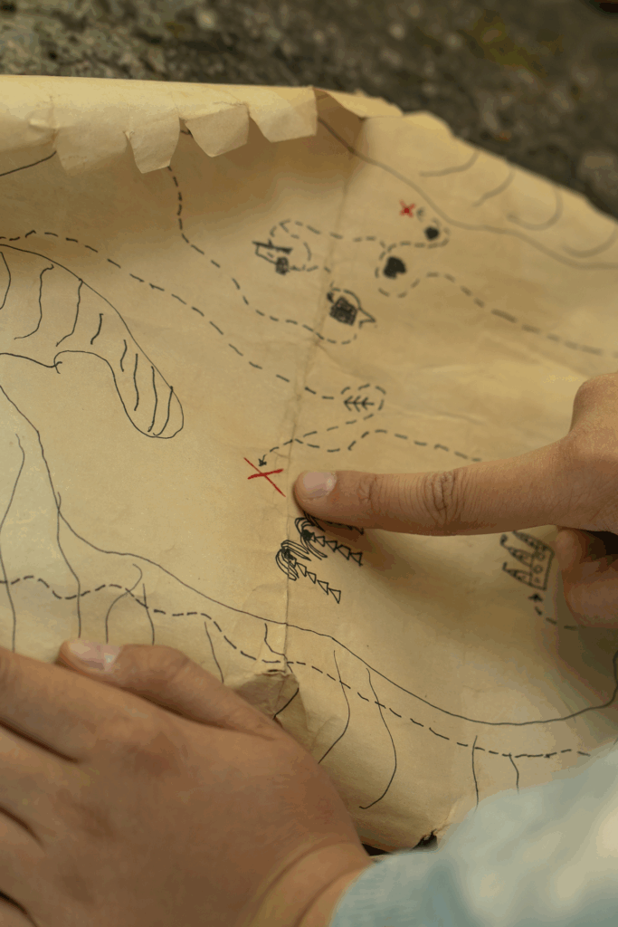 Finger, die auf eine Schatzkarte zeigen