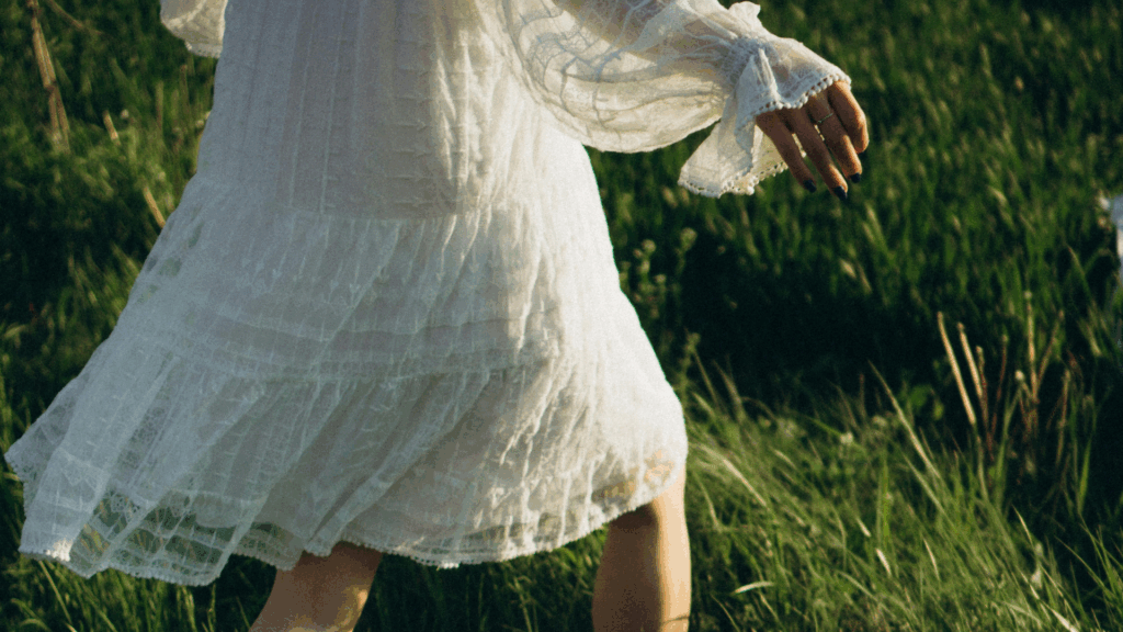 Eine Frau im weißen Kleid läuft durch Wiese