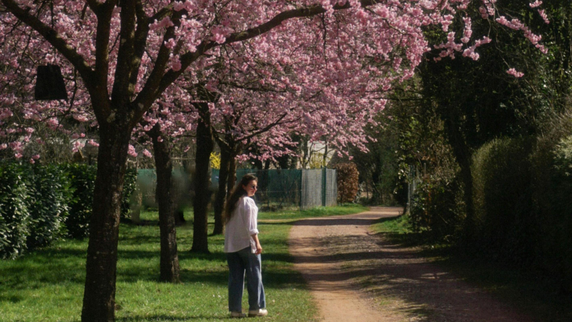 Eine Frau steht vor einem blühenden Baum