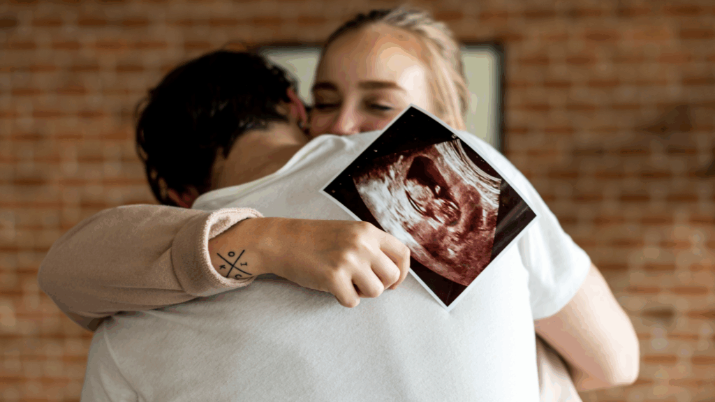 Tiny Feet: Glückliches Paar hällt Ultraschallbild vom Baby in den Händen