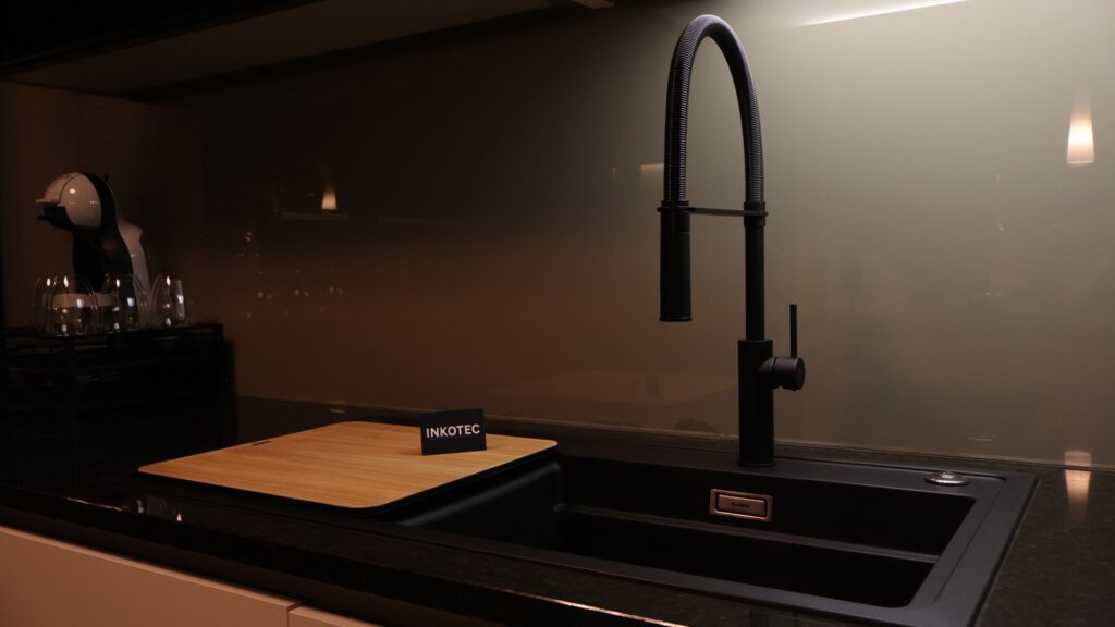 Spüle in Schwarz in einer Küche mit INKOTEC Logo