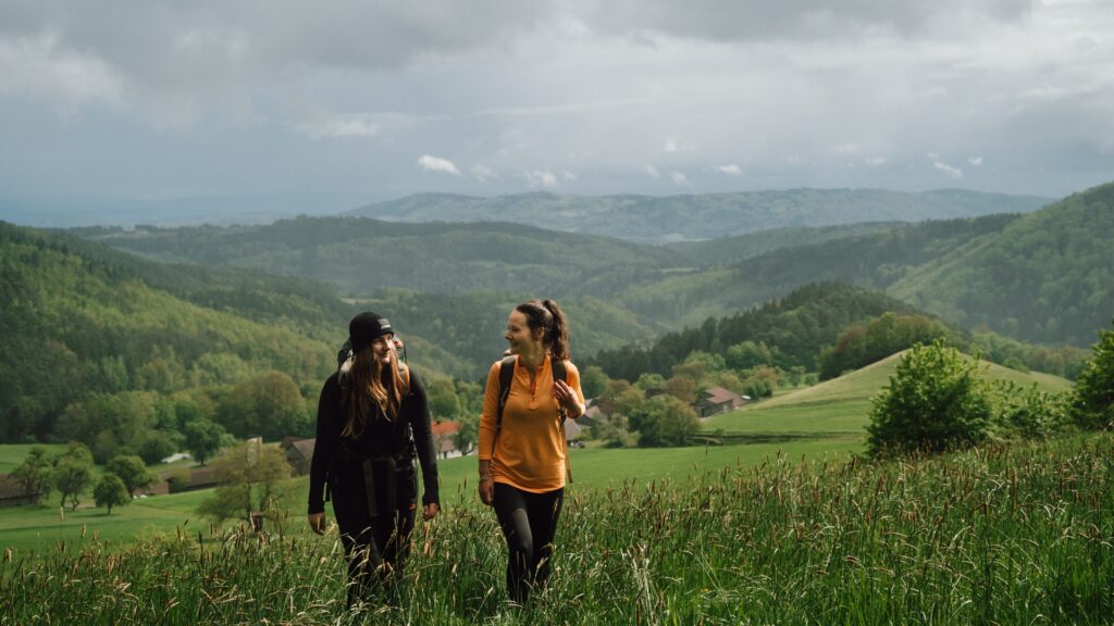 Zwei Frauen wandern durch Wiese