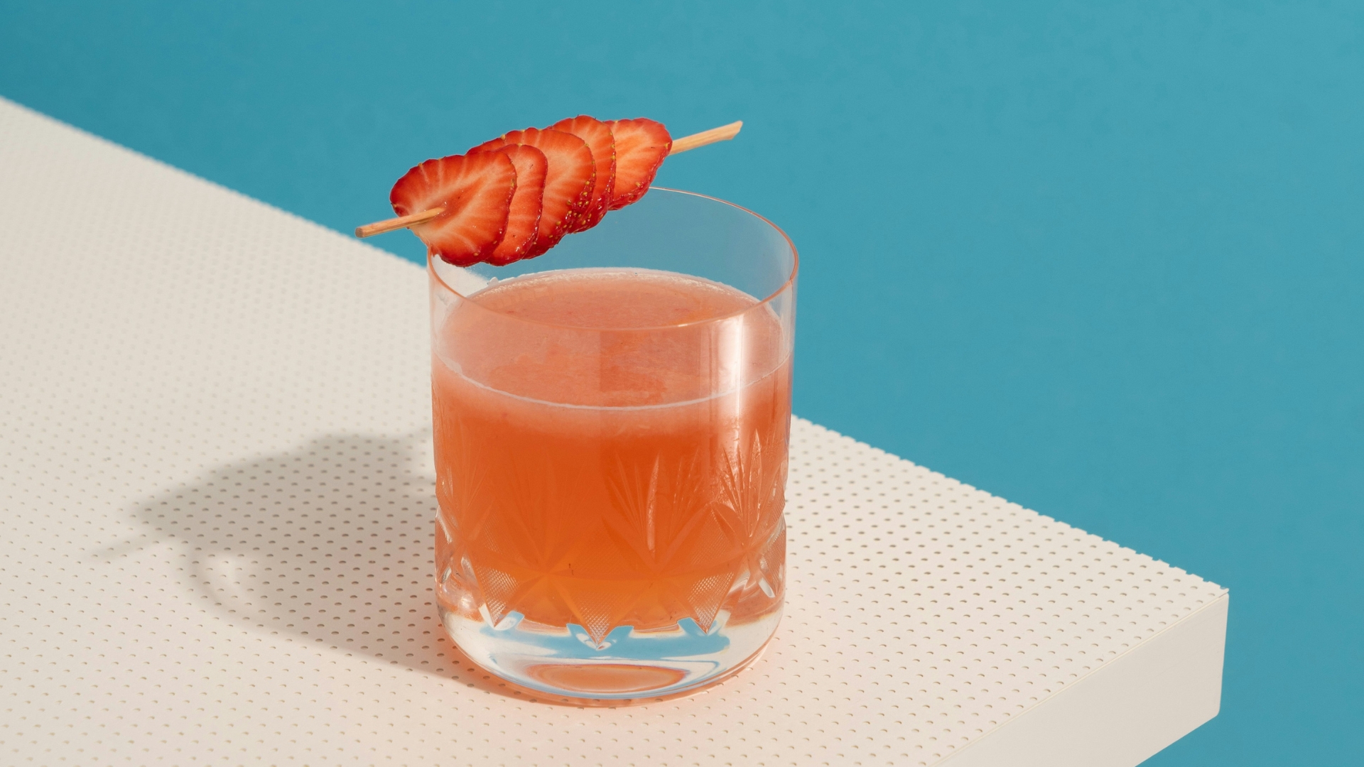 Oranger Cocktail mit Erdbeer-Garnitur in Whisky-Glas